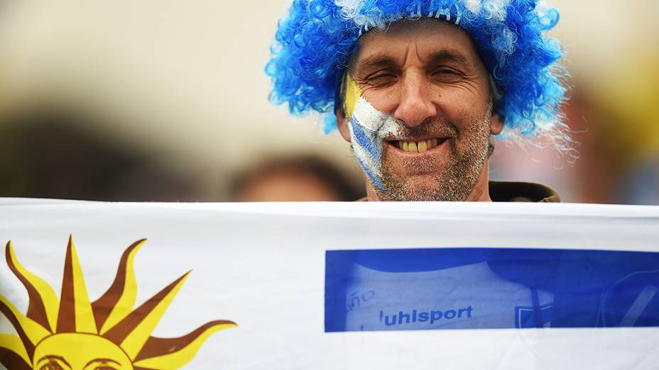 Torcedor do Uruguai segura a bandeira do país antes da partida contra a Inglaterra no Itaquerão, em São Paulo