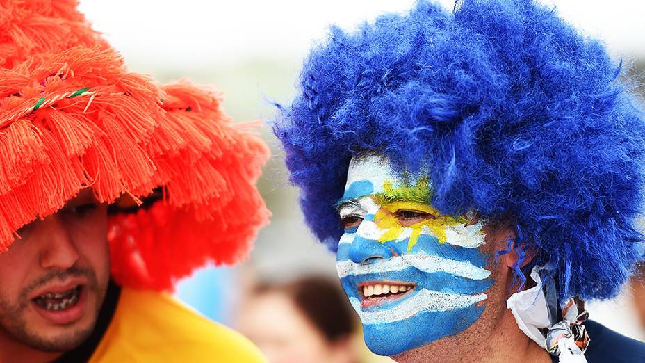 Torcedor pinta o rosto com a bandeira do Uruguai antes do jogo contra a Inglaterra no Itaquerão, em São Paulo