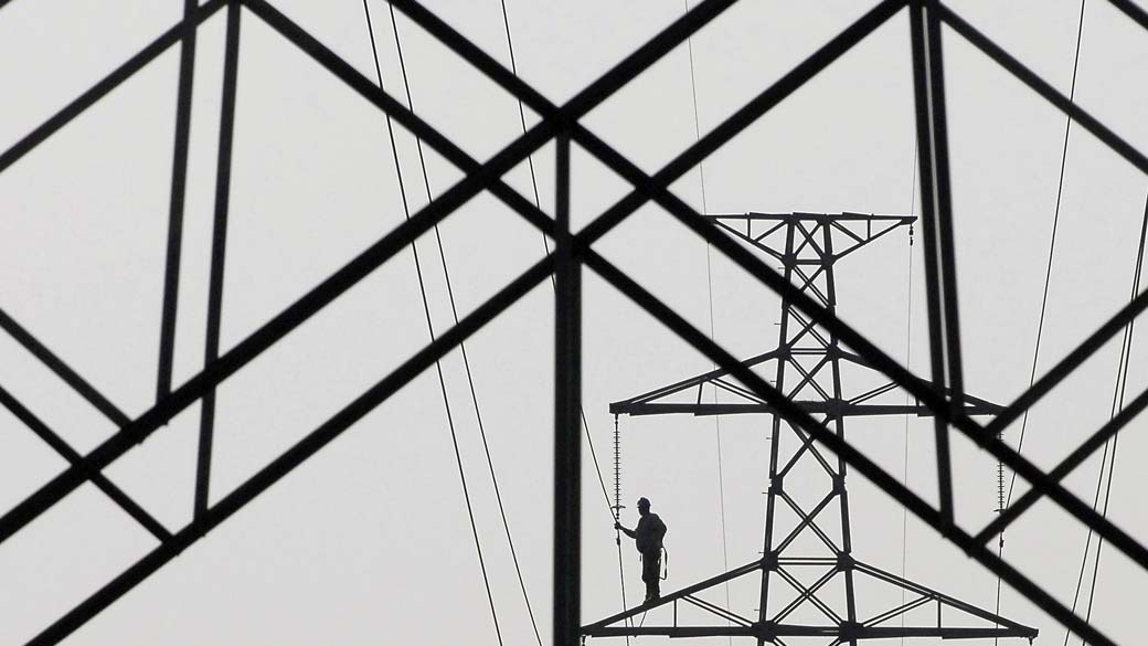 Funcionário repara torre de alta tensão na província de Jiangsu, na China