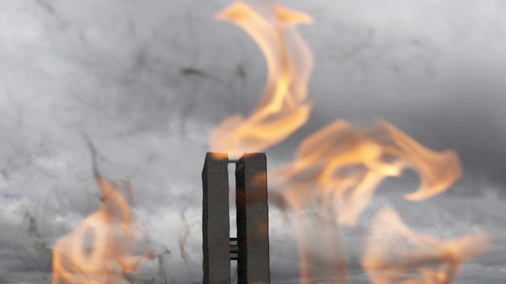Torres do Congresso Nacional vistas através da chama simbólica da Pira da Pátria na Praça dos Três Poderes, em Brasília