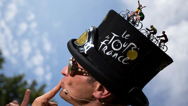 Artista vestindo um chapéu decorado, posa para foto durante volta da França