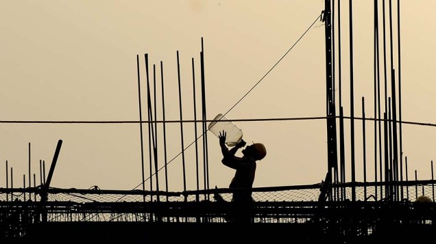 Trabalhador em construção na cidade de Nova Délhi, Índia