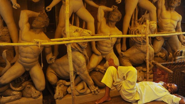 Funcionário descansa em fábrica de máscaras de argila em Calcutá, Índia