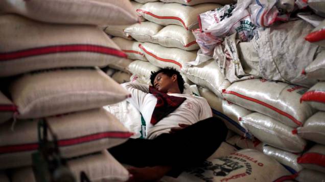Trabalhador descansa em depósito de arroz na cidade de Jacarta, Indonésia