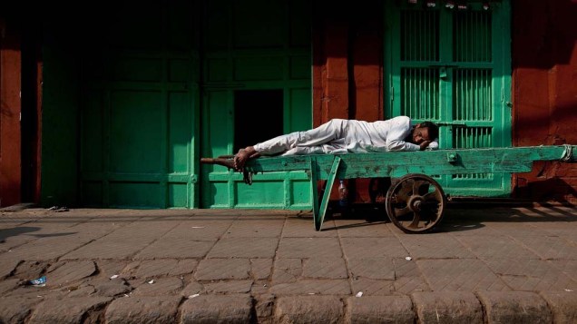 Trabalhador descansa durante greve geral dos comerciantes contra a decisão do governo de permitir 51% de Investimento Estrangeiro Direto em empresas do varejo em Nova Délhi, Índia