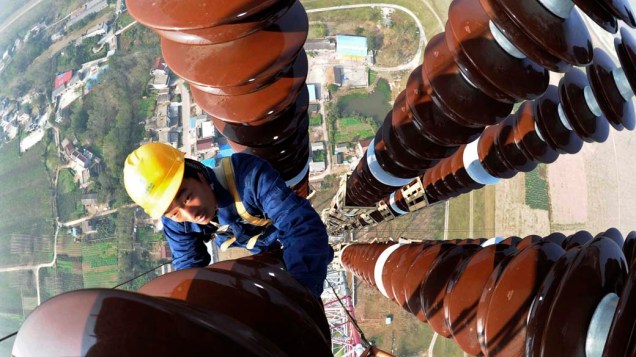 Trabalhador faz ajustes em poste de eletricidade na cidade de Anqing, China