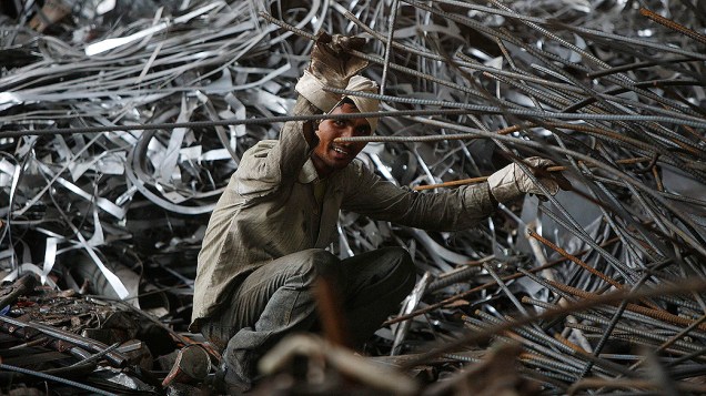 Homem trabalha dentro de uma fábrica de aço nos arredores de Jammu, na Índia