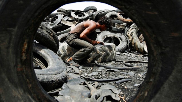 Homem trabalha em um depósito de sucata nos arredores de Ahmedabad, na Índia