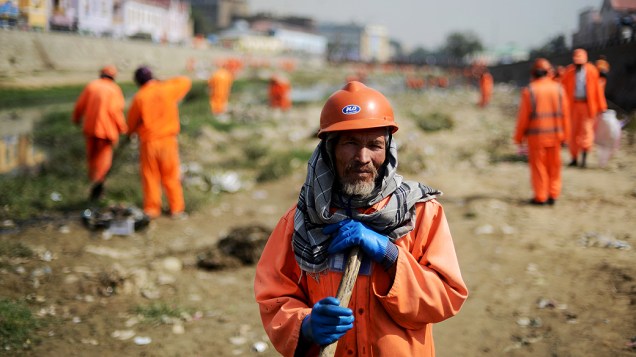 Trabalhadores afegãos limpam rio poluído, em Cabul, capital do Afeganistão