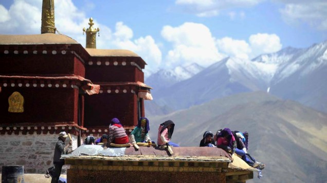 Tibetanos consertam o telhado do monastério Drepung, na cidade chinesa de Lhasa
