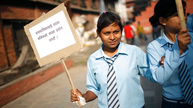 Estudante com um cartaz durante comício organizado para marcar o Dia Mundial Contra o Trabalho Infantil, em Katmandu, no Nepal