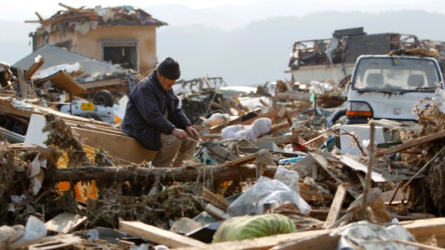 Japonês observa restos das casas da cidade de Rikuzentakata, após o forte tsunami que atingiu a cidade