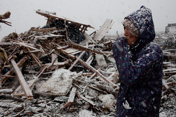 Japonesa de 74 anos chora diante de sua casa devastada pelo tsunami que atingiu a região de Iwate