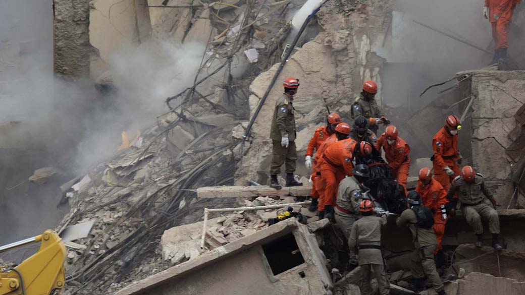 Bombeiros retiram corpo dos escombros nesta manhã (26/01) do desabamento de 3 prédios no Rio de Janeiro, na noite do dia 25 de janeiro
