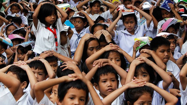 Estudantes filipinos cobrem suas cabeças em simulação de terremoto em escola de Manila