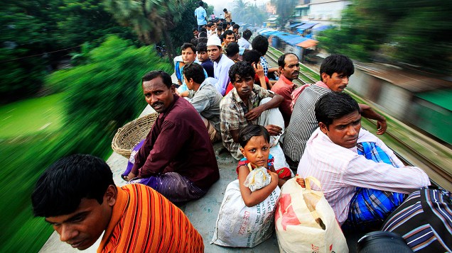 Passageiros sobre o teto de um trem superlotado que faz o trajeto de Dhaka em direção a Jamalpur, em Bangladesh