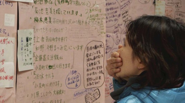 Mulher olha quadro de mensagens das pessoas que evacuaram a cidade Rikuzentakata, no Japão
