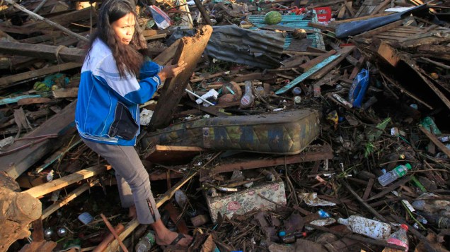 Moradora da região de Cagayan de Oro, atingida por tufão, anda por destroços - 18/12/2011