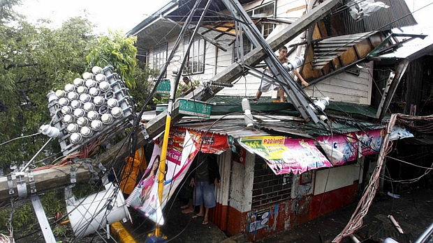 Passagem do Nesat pelas Filipinas deixou estragos nesta terça-feira: poste de iluminação destrói casa localizada em Tondo, cidade na região metropolitana da capital Manila.