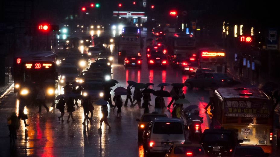 Pessoas caminham durante chuva e ameaça de Tufão em Taiwan