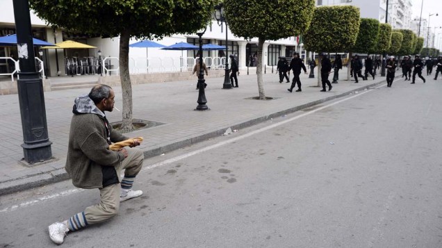Manifestante empunha pão como arma, durante protesto contra o novo governo do país, na Tunísia