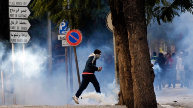 Manifestantes correm da polícia durante confronto em Tunis, capital da Tunísia - 14/01/2011