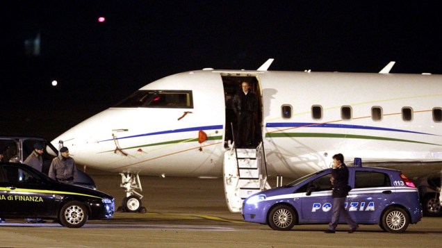 Carros da polícia italiana acompanham o avião do ex-presidente da Tunísia, Zine El Abidine Ben Ali, durante o desembarque no aeroporto de Elmas Cagliari em Sardenha, na Itália - 14/01/2011