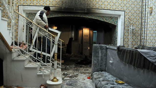 Homem saqueia a casa de Belhassen Trabelsi, cunhado do ex-presidente Zine El Abidine Ben Ali, em Sokra, na Tunísia - 15/01/2011
