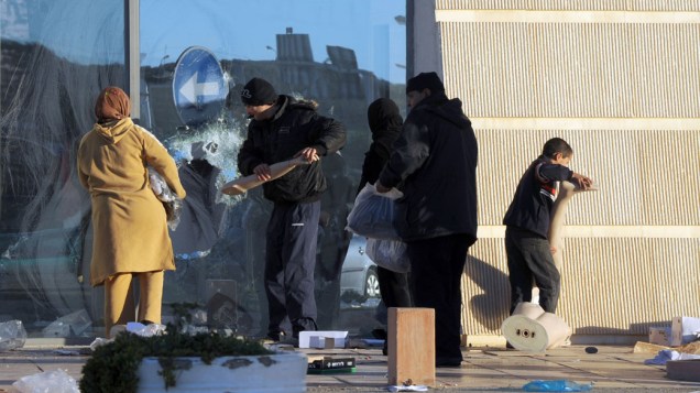 Pessoas saqueiam loja em La Gazella, cidade próxima a capital Tunis, na Tunísia - 15/01/2011