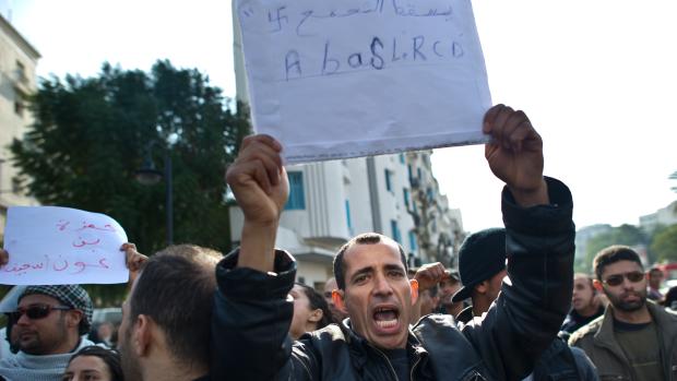 Manifestante em Tunis segura placa dizendo "Abaixo o RCD (partido de Ben Ali)"