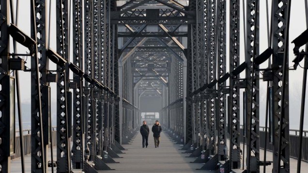Turistas caminham na antiga Ponte Yalu, China
