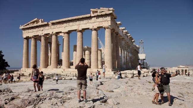 Turistas visitam o Partenon, na Acrópole de Atenas, Grécia