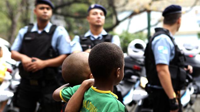 Crianças observam os novos policiais da comunidade