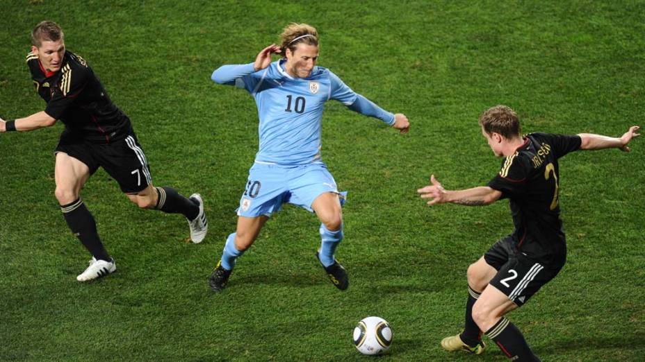 Lance entre Diego Forlan, Schweinsteiger e Marcell Jansen durante partida entre Uruguai e Alemanha pela disputa dos terceiro e quarto lugares da Copa do Mundo da África do Sul