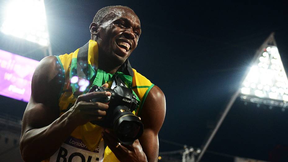 Usain Bolt tira foto com câmera de fotógrafo após a conquista dos 200 m rasos em Londres