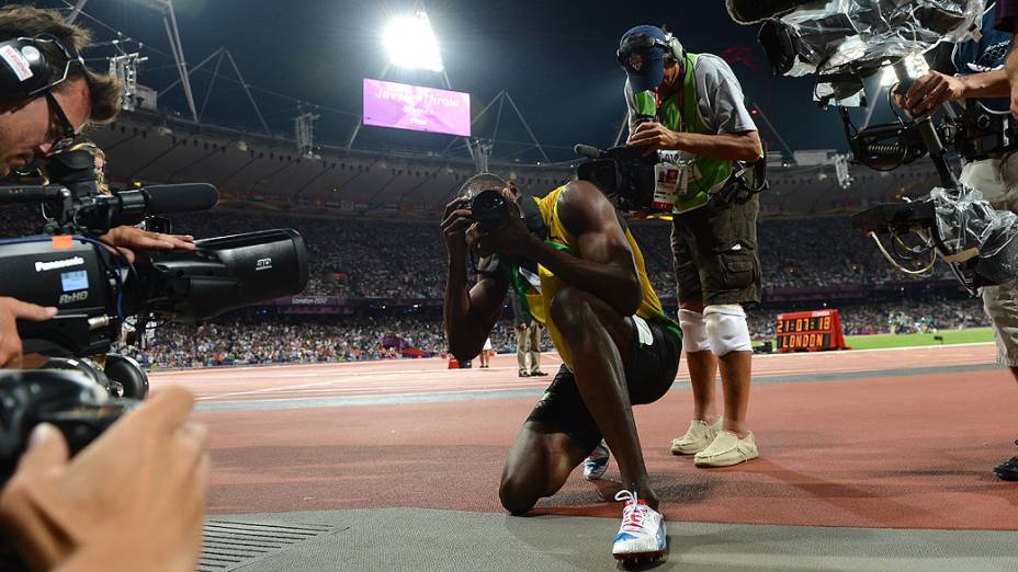 Usain Bolt tira foto com câmera de fotógrafo após a conquista dos 200 m rasos em Londres