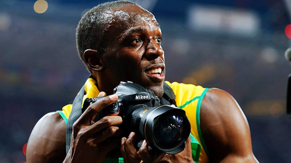 Usain Bolt tira foto com câmera de fotógrafo após a conquista dos 200 m rasos em Londres