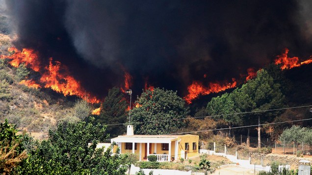 Fogo se alastra próxima a uma residência em Pedralba, no interior de Valência, Espanha, onde os fortes ventos dificultam a ação dos bombeiros desde a madrugada