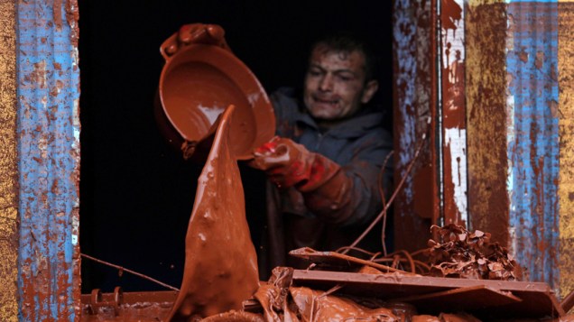 Homem retira lama de sua casa, em Devecser, Hungria. O vazamento de lama tóxica de uma empresa de alumínio inundou 40 quilômetros da região sudoeste do país, matando quatro pessoas e desabrigando centenas de famílias