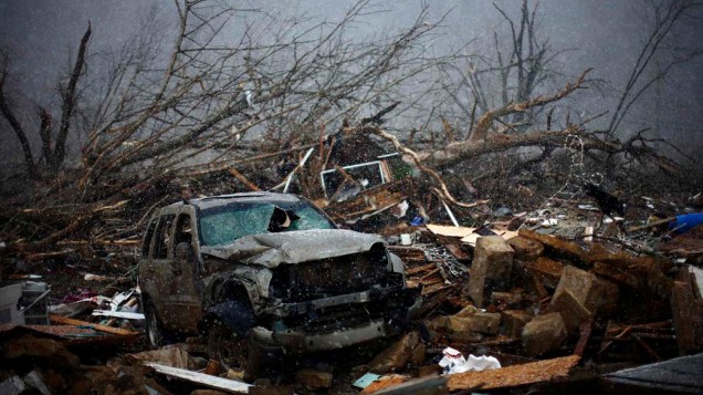 Veículo danificado entre destroços deixados por tornados e tempestades em West Liberty, Estados Unidos