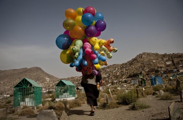Vendedor de balões anda por cemitério da cidade velha de Cabul