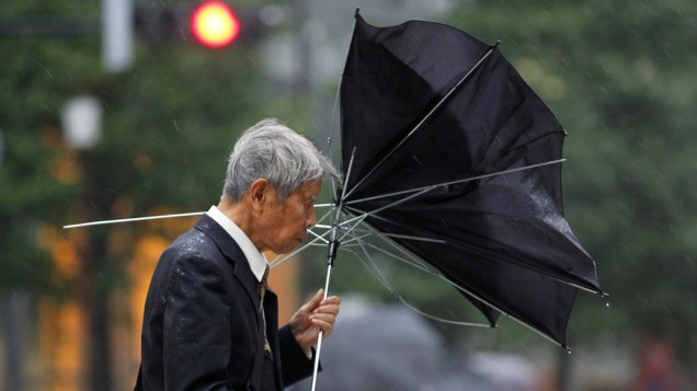 No Japão, pedestre caminha pelas ruas de Tóquio durante ventania provocada pelo tufão Roke