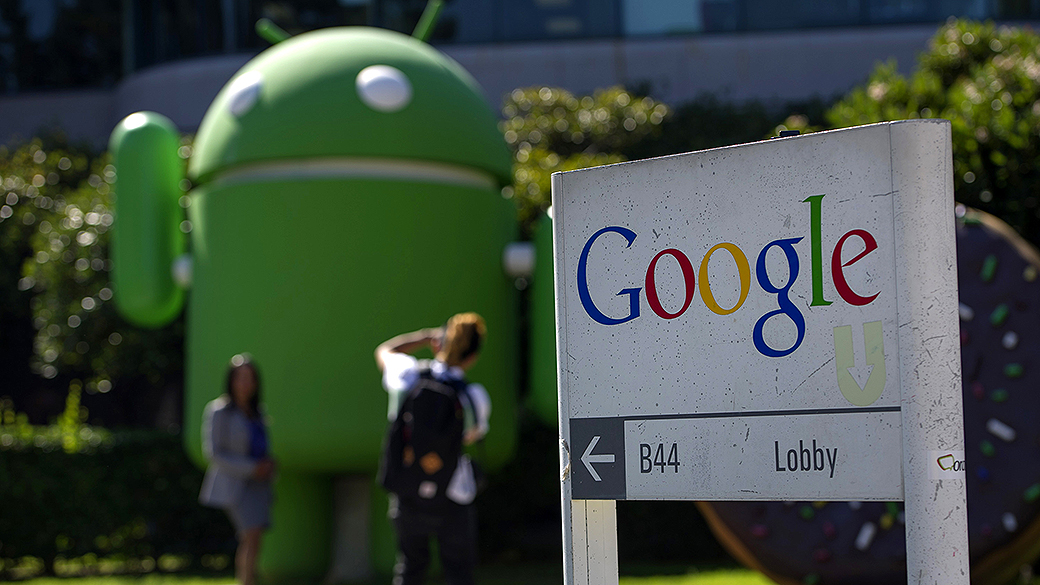Pedestres tiram fotos em frente ao edifício de escritórios da Google Inc. na sede da empresa em Mountain View, Califórnia