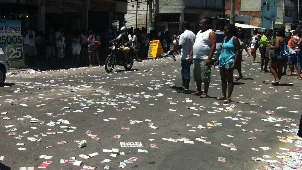 Santinhos cobrem o asfalto na Vila Aliança, onde Eduardo Paes acompanhou o voto de seu cendidato a vice, Adilson Pires (PT)
