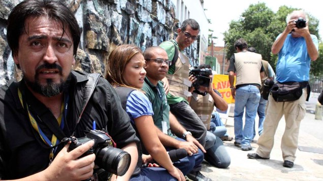 Na quinta-feira, dia 25 de novembro, jornalistas se protegem na Vila Cruzeiro, Rio de Janeiro