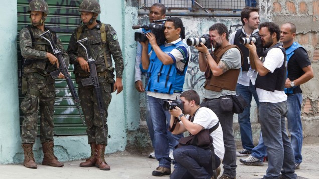 Jornalistas e fotógrafos acompanham o cerco militar no Complexo do Alemão, no Rio de Janeiro. 27/11/2010