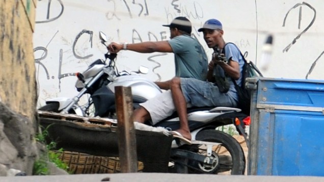 Traficantes passam de motocicleta por rua do Complexo do Alemão, no Rio de Janeiro. 27/11/2010
