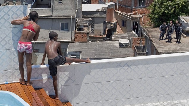 Crianças brincam na piscina da casa do traficante carioca, após a polícia desocupar o local - 28/11/2010