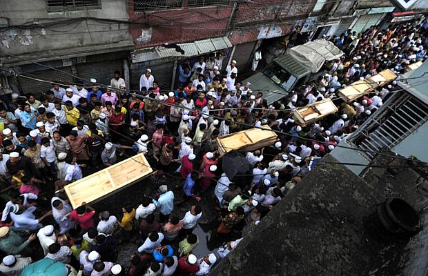 População de Bangladesh carrega caixões de vítimas do incêndio, em Dacca