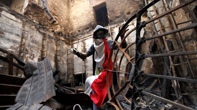 Voluntário recupera manuscritos queimados nas ruínas do Instituto do Egito após incêndio causado por confrontos da praça Tahrir, no Cairo